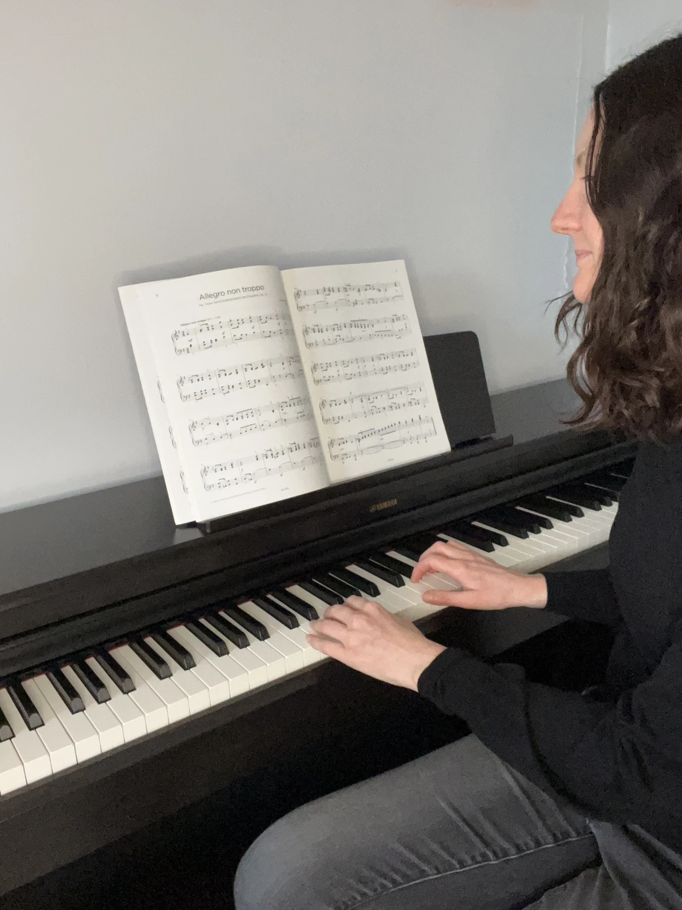 Lisa playing the piano in her teaching studio